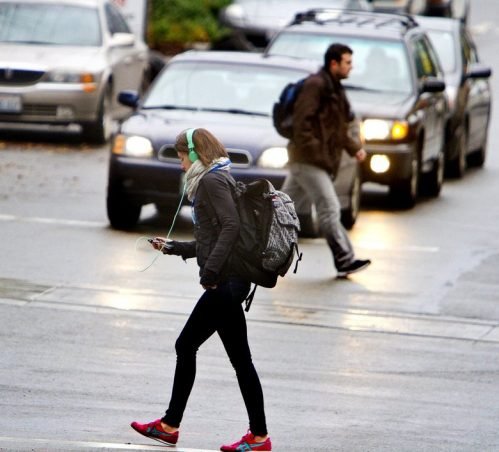 woman crossing street woman crossing street with headphones on